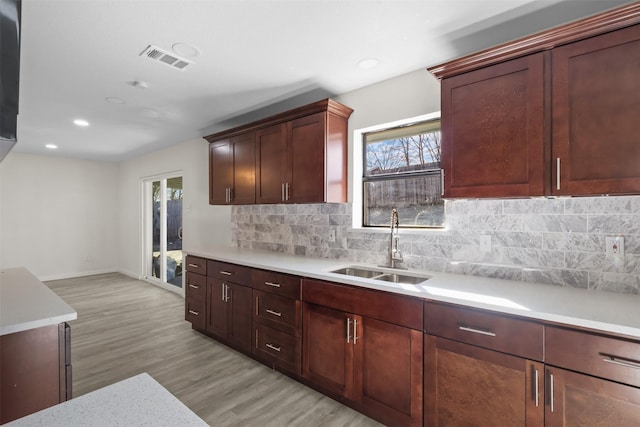 kitchen featuring sink, decorative backsplash, and light hardwood / wood-style flooring