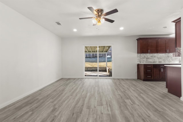 unfurnished living room featuring ceiling fan and light hardwood / wood-style flooring