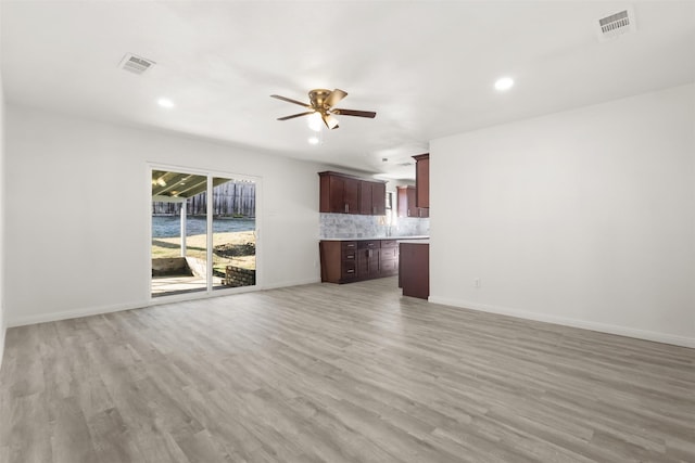 unfurnished living room with ceiling fan and light wood-type flooring