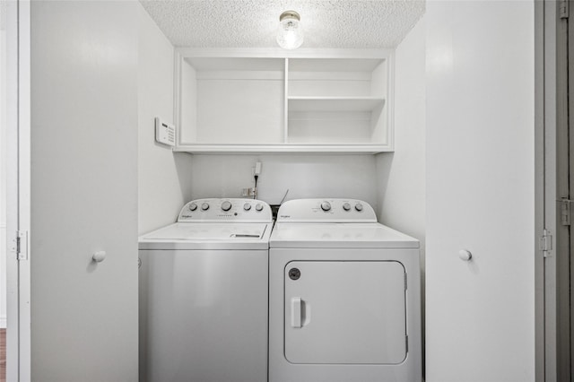 laundry room with washing machine and clothes dryer and a textured ceiling