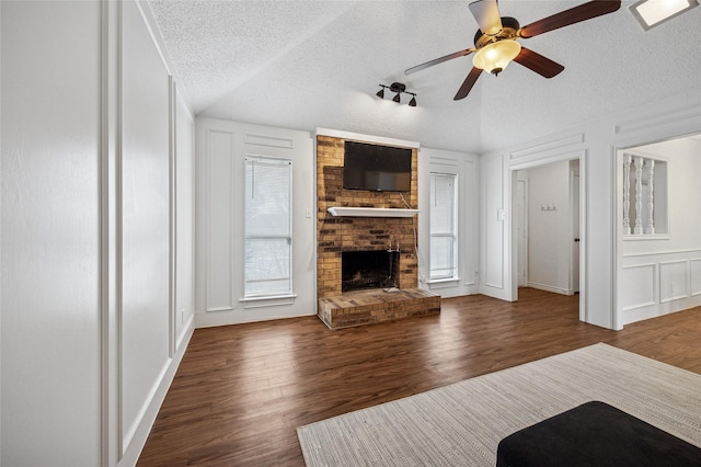 unfurnished living room featuring a fireplace, dark hardwood / wood-style flooring, and a textured ceiling