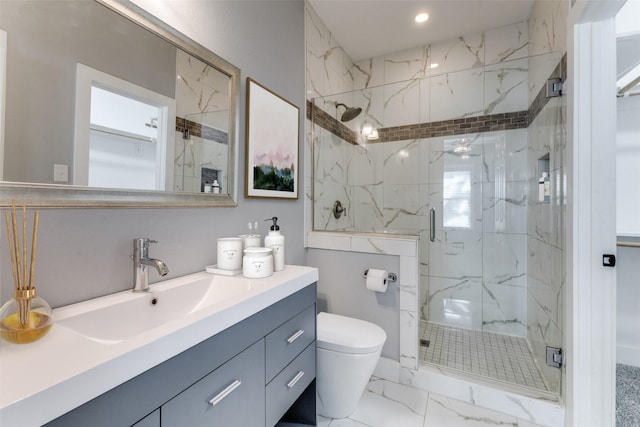 bathroom featuring vanity, toilet, and a shower with shower door