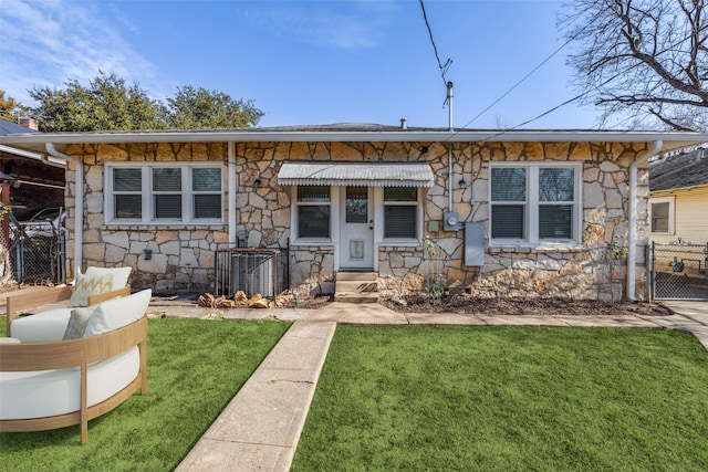 view of front of property featuring central AC unit and a front yard