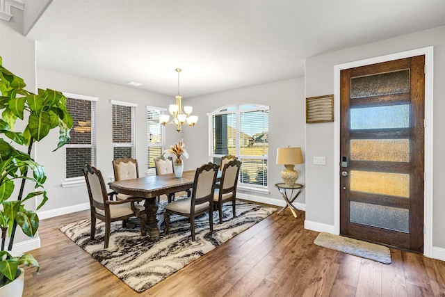 dining area featuring hardwood / wood-style flooring and a notable chandelier