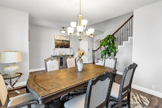 dining space featuring wood-type flooring and a chandelier