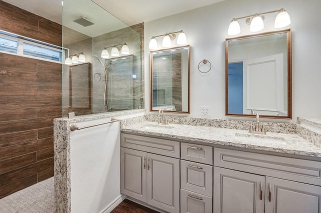 bathroom featuring a tile shower and vanity