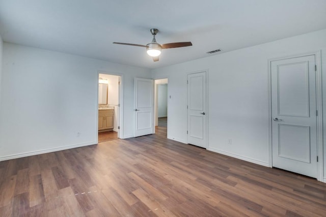 unfurnished bedroom with ensuite bath, ceiling fan, and hardwood / wood-style flooring