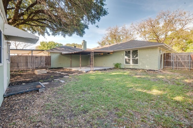 back of house with a patio and a lawn