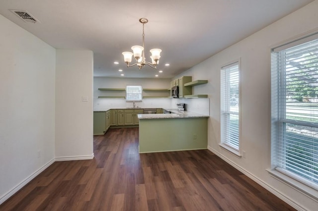 kitchen with stainless steel appliances, green cabinets, kitchen peninsula, dark hardwood / wood-style flooring, and a chandelier