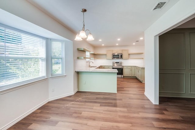 kitchen featuring decorative light fixtures, stainless steel appliances, an inviting chandelier, and light hardwood / wood-style flooring