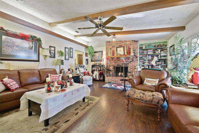 living room with a textured ceiling, ceiling fan, hardwood / wood-style floors, and a brick fireplace