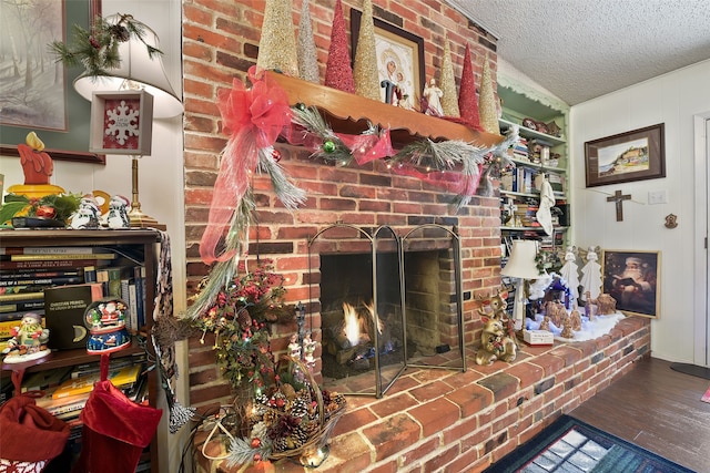 living room with a textured ceiling, hardwood / wood-style floors, and a fireplace