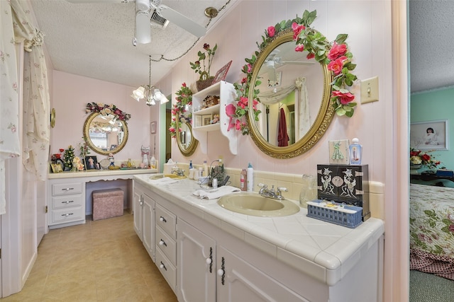 bathroom featuring tile patterned floors, vanity, a textured ceiling, and an inviting chandelier