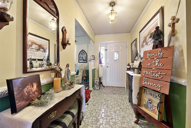 entrance foyer with a textured ceiling, crown molding, and light tile patterned floors