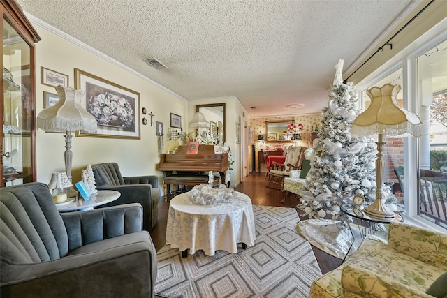 living room featuring a textured ceiling, crown molding, and hardwood / wood-style floors