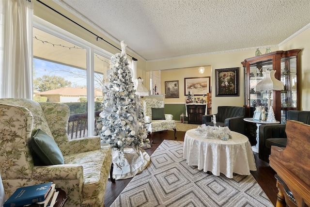 living room featuring a textured ceiling, light hardwood / wood-style floors, and ornamental molding