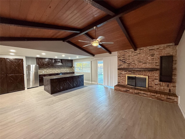 unfurnished living room featuring a ceiling fan, lofted ceiling with beams, wood ceiling, light wood finished floors, and a brick fireplace