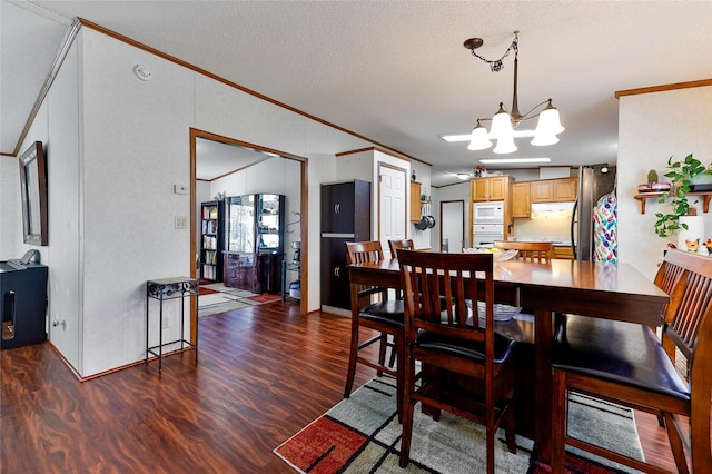 dining space with a textured ceiling, ornamental molding, a notable chandelier, and dark wood-type flooring