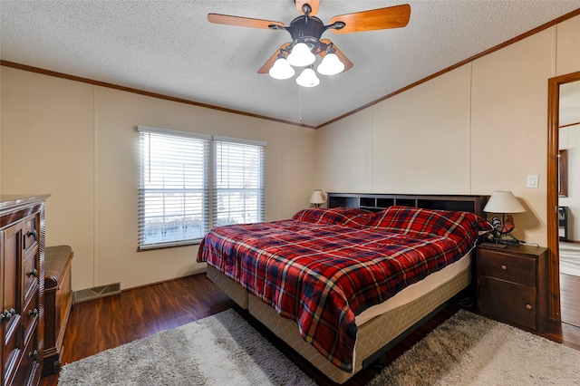 bedroom with ceiling fan, dark wood-type flooring, ornamental molding, and a textured ceiling