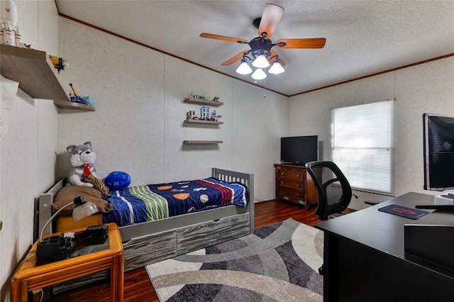 bedroom with a textured ceiling, ceiling fan, crown molding, and dark wood-type flooring