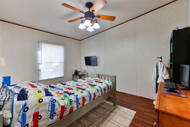 bedroom featuring ceiling fan, dark wood-type flooring, crown molding, and a textured ceiling