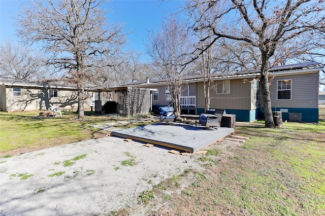 rear view of property with a yard and outdoor lounge area