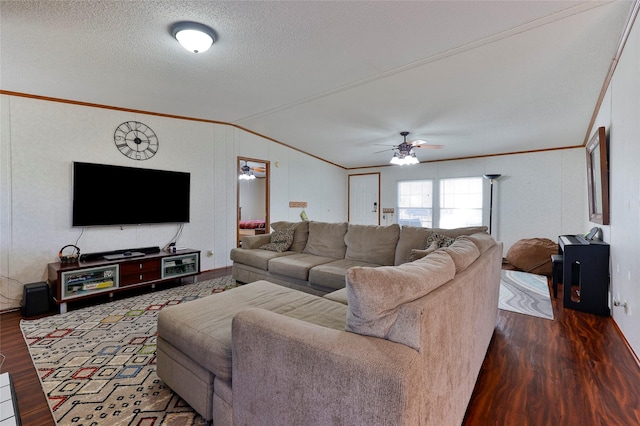 living room featuring a textured ceiling, dark hardwood / wood-style flooring, ornamental molding, and vaulted ceiling