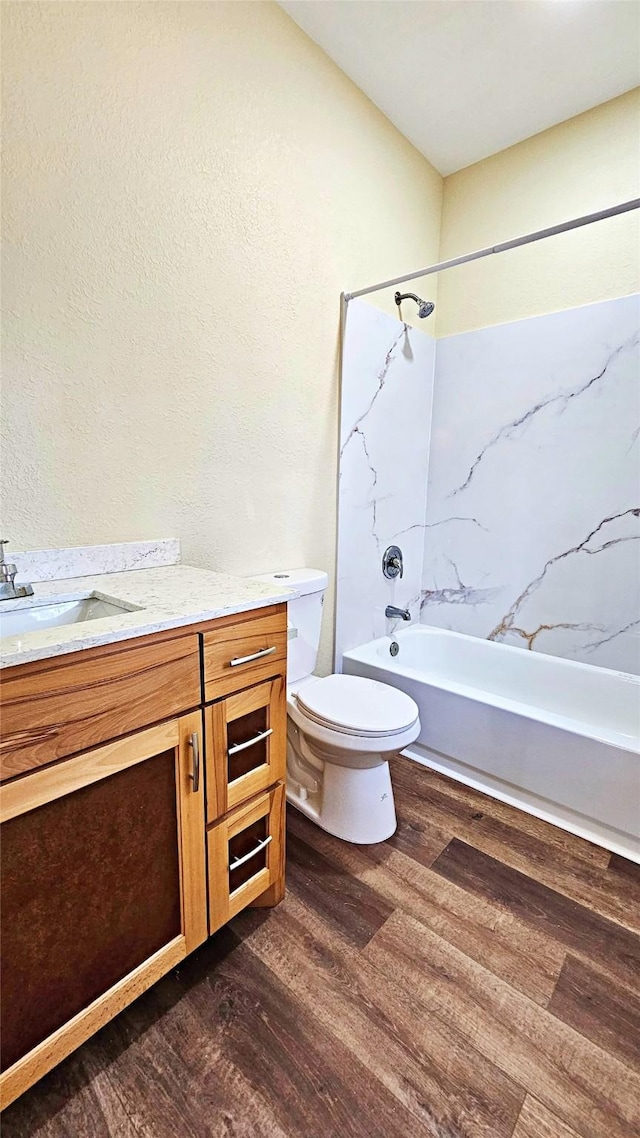 full bathroom featuring toilet, vanity, hardwood / wood-style floors, and shower / bathing tub combination