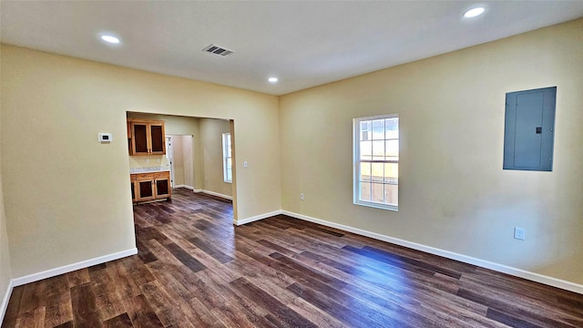 empty room featuring electric panel and dark hardwood / wood-style floors