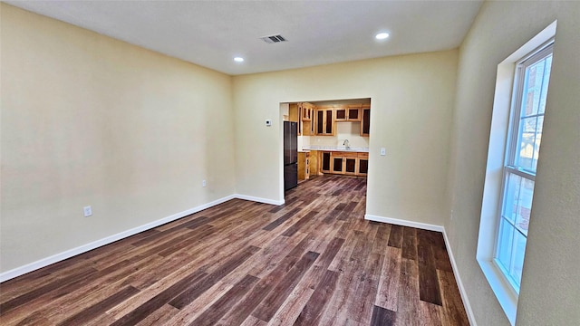 spare room featuring sink and dark wood-type flooring