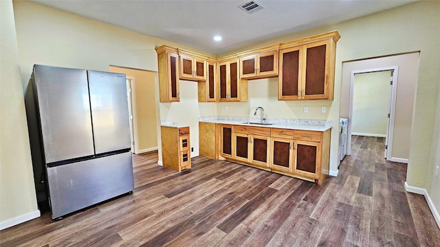 kitchen featuring sink, stainless steel fridge, and dark wood-type flooring