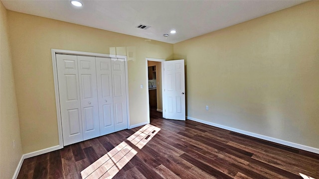 unfurnished bedroom featuring a closet and dark hardwood / wood-style floors