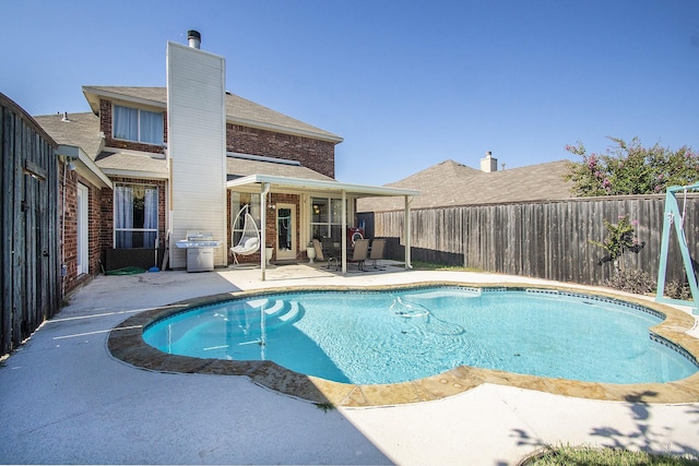 view of swimming pool featuring a grill and a patio