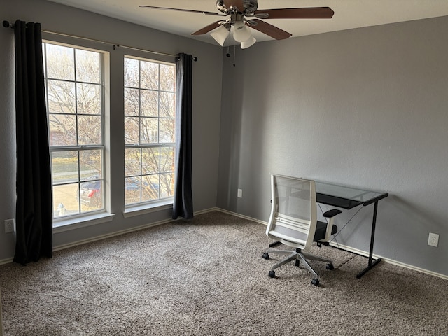 unfurnished office with ceiling fan and carpet flooring