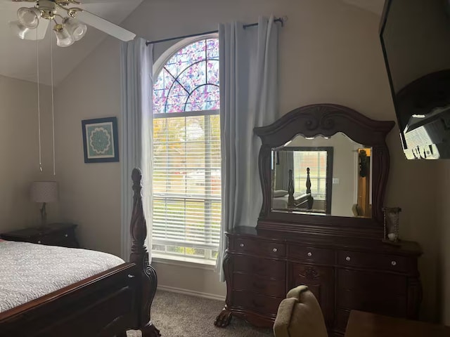 bedroom with ceiling fan, carpet flooring, and lofted ceiling