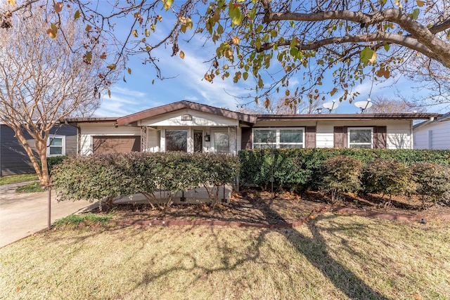 ranch-style home with a garage and a front lawn