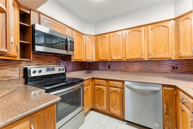 kitchen featuring light stone countertops, stainless steel appliances, and tasteful backsplash