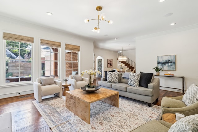 living room featuring ornamental molding, light hardwood / wood-style floors, and a chandelier