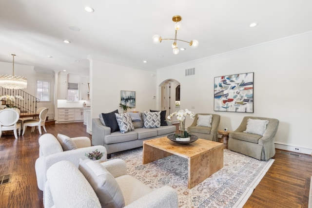 living room featuring an inviting chandelier, crown molding, and hardwood / wood-style flooring