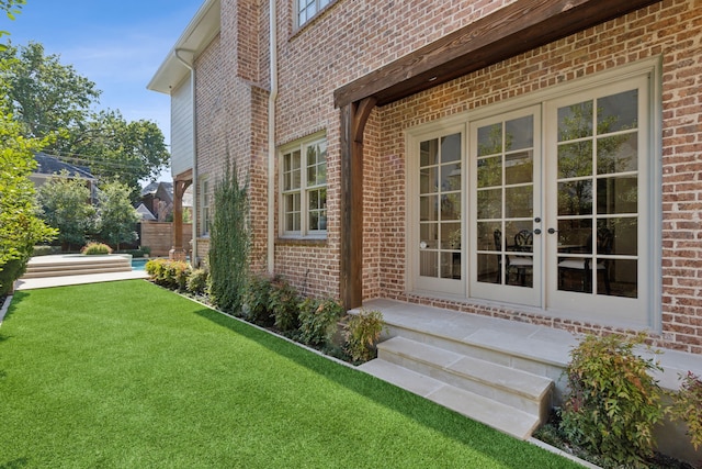 view of side of property featuring french doors and a yard