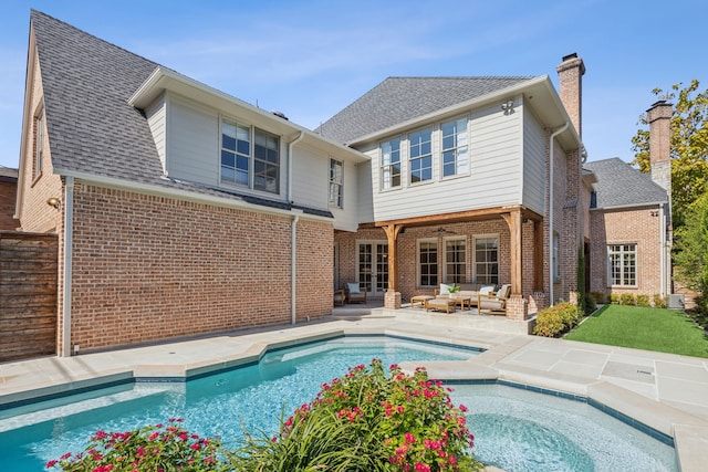 rear view of property featuring a patio area and an outdoor living space