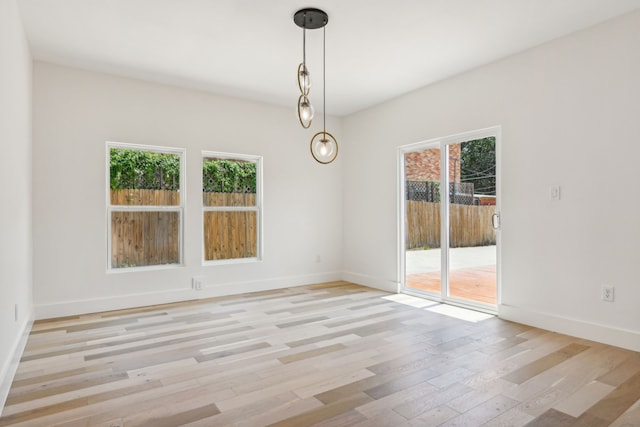 unfurnished dining area featuring light wood-type flooring and a wealth of natural light