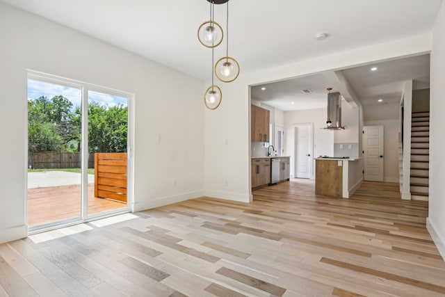 unfurnished living room featuring light hardwood / wood-style floors and sink