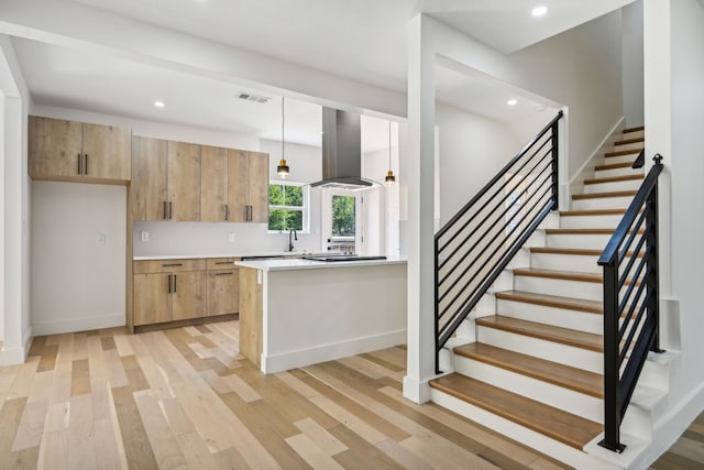 kitchen with sink, island exhaust hood, light hardwood / wood-style flooring, light brown cabinetry, and pendant lighting