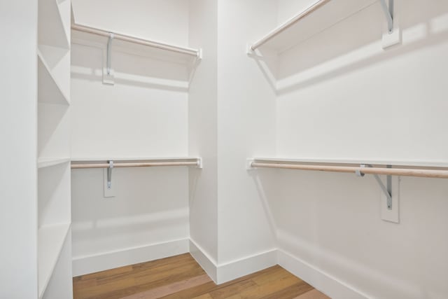 walk in closet with hardwood / wood-style floors