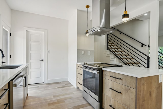 kitchen featuring sink, decorative light fixtures, light wood-type flooring, island exhaust hood, and appliances with stainless steel finishes