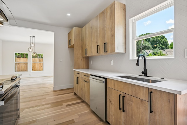 kitchen with appliances with stainless steel finishes, sink, light hardwood / wood-style flooring, decorative light fixtures, and backsplash