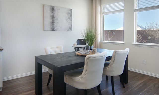 dining space with a healthy amount of sunlight and dark hardwood / wood-style floors