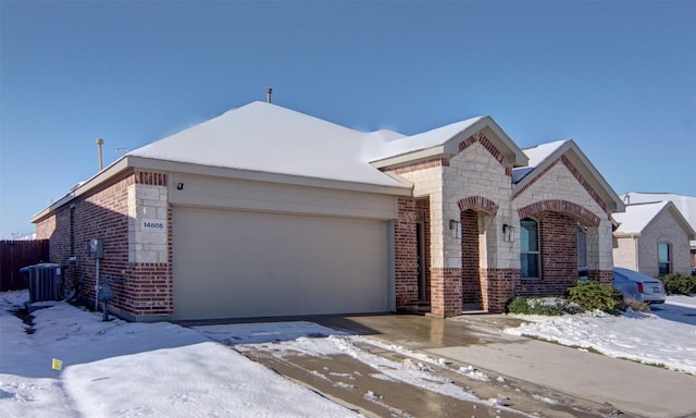 view of front of home with a garage and central AC