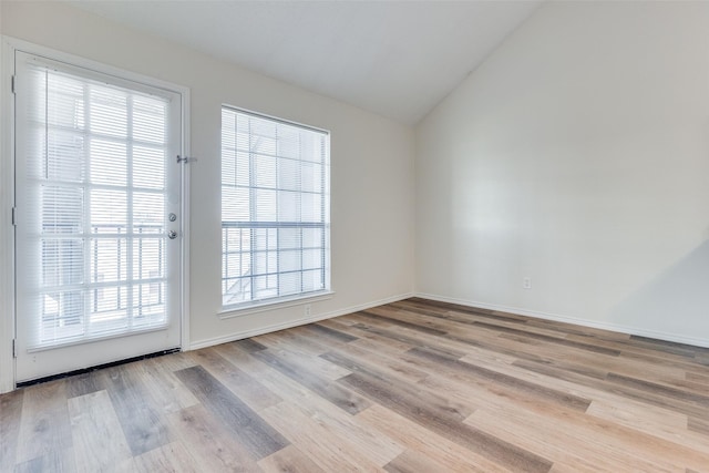 entryway featuring a healthy amount of sunlight, light hardwood / wood-style floors, and lofted ceiling